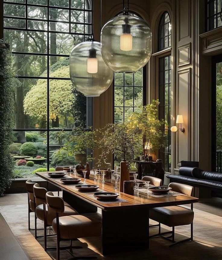 an elegant dining room with large windows and chandeliers hanging from the ceiling above it