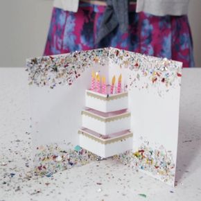 a birthday card with three candles on it and confetti all over the place