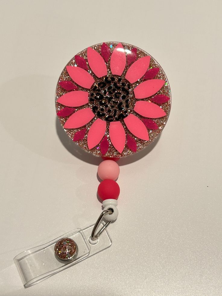 "This adorable 2\" badge reel features a rose gold glitter, leopard print center, and customizable flower petal colors. With a rotating alligator clip back and matching beaded retractable line, it's perfect for nurses, teachers, administrators, and anyone with a badge ID card.  Please message me with questions or custom requests! Flower measures 2\"x2\" 3 10mm matching beads Retractable badge reel Rotating alligator clip attachment Please note: All badge reels are made to order and take 2-3 days processing. As they are custom made, there may be color variation in the glitter. These are acrylic and resin design - while they are durable, they aren't invincible. Dropping may result in breaking." Diy Badge Reel How To Make Epoxy, Pink Badge Reel With Swivel Clip As Gift, Customizable Adjustable Pink Badge Holders, Customizable Adjustable Pink Badge Reel, Badge Reels Diy, Epoxy Design, Badge Ideas, Leopard Flower, Reel Ideas