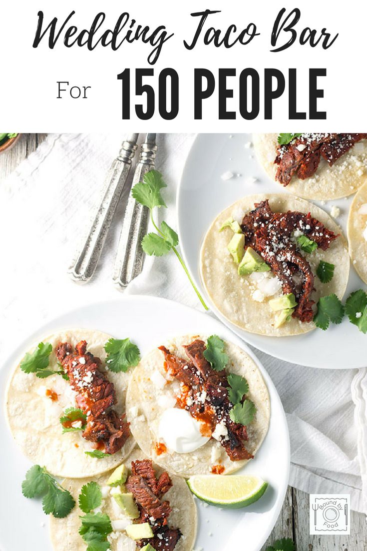 two plates filled with tacos on top of a white wooden table next to silverware