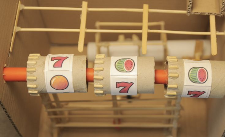 three rolls of toilet paper with stickers on them in a box next to clothes pegs