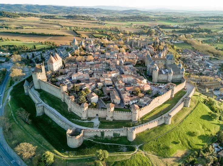 an aerial view of a castle in the middle of a town with lots of green grass