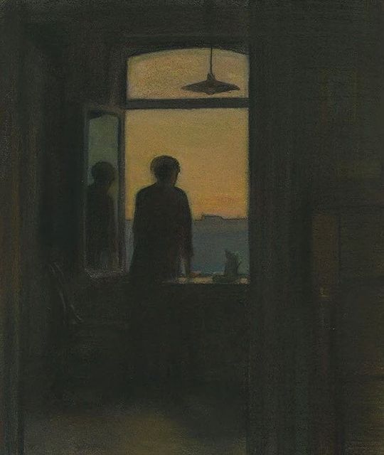 two people standing in front of a window looking out at the ocean