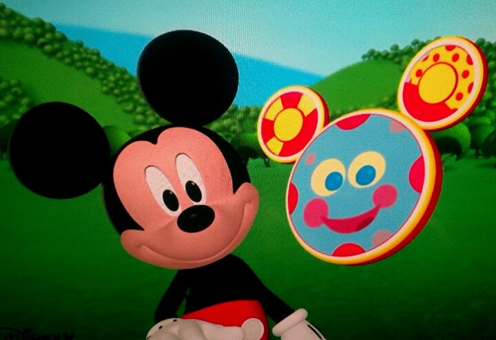 a mickey mouse is standing in front of a painting