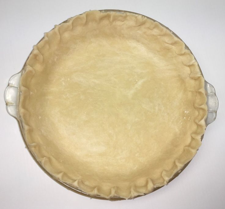 an uncooked pie crust on a white table with no one in the photo