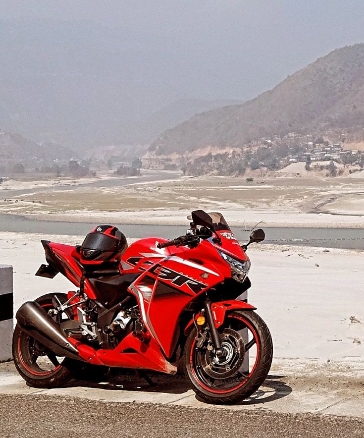 a red motorcycle is parked on the beach