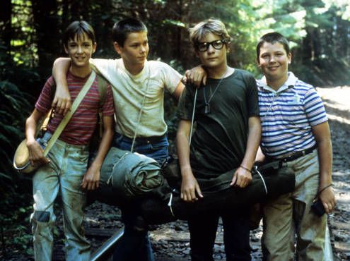 four young men standing next to each other in the woods