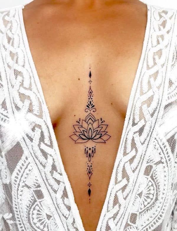 a woman's chest with a tattoo on her left side and an intricate flower in the middle