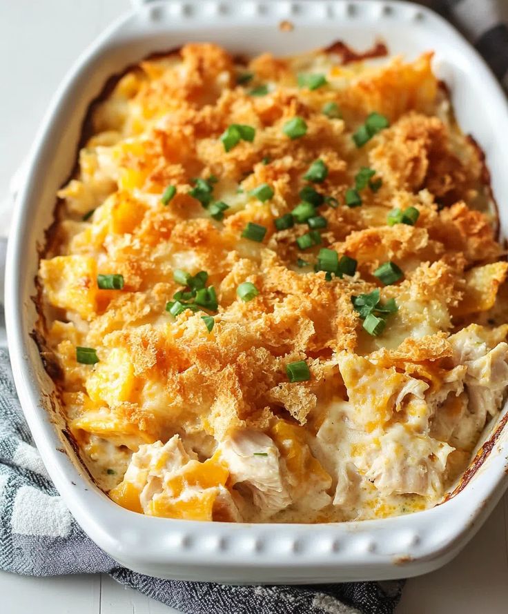 a casserole dish with chicken, cheese and green onions in it on a table