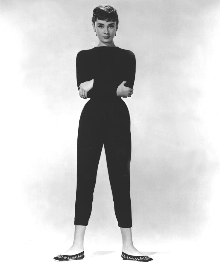 a black and white photo of a woman in high heels standing with her back to the camera