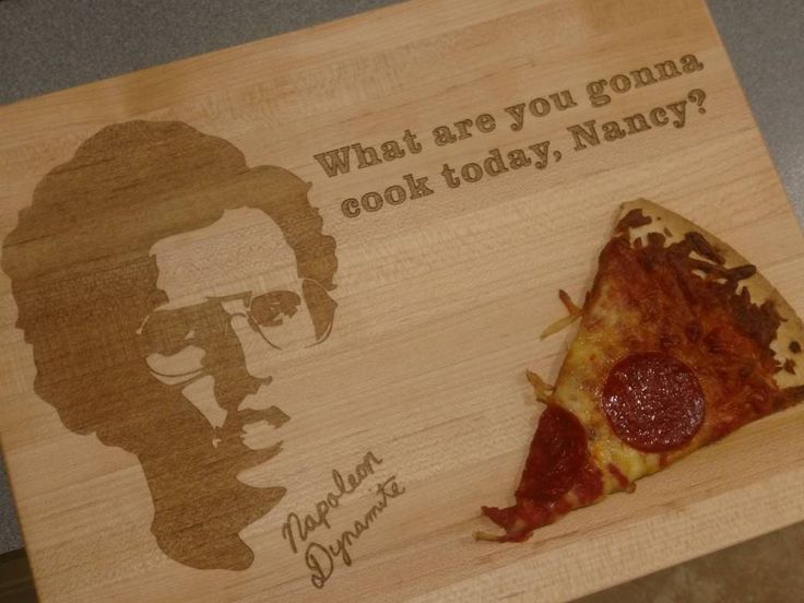 a wooden cutting board with a piece of pizza on it and an image of a man's face