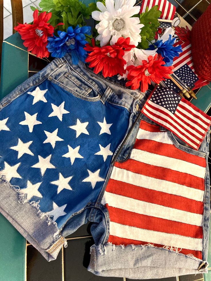 an american flag and flowers are sitting on the floor next to jean shorts that have been cut off