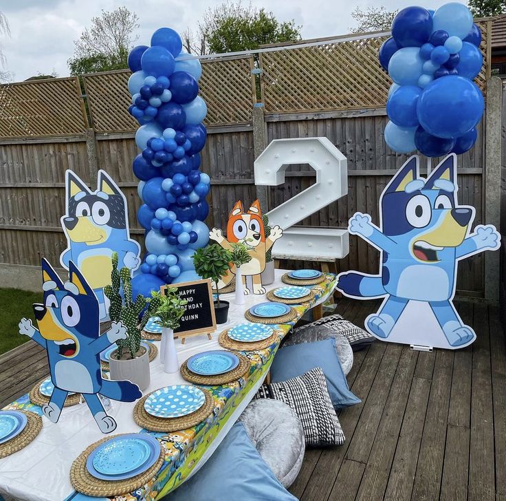 a table set up with blue balloons, plates and decorations for an angry birds birthday party