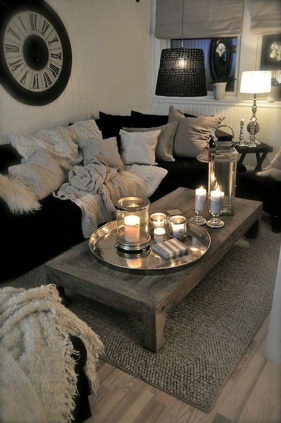 a living room filled with lots of furniture and candles on top of a coffee table