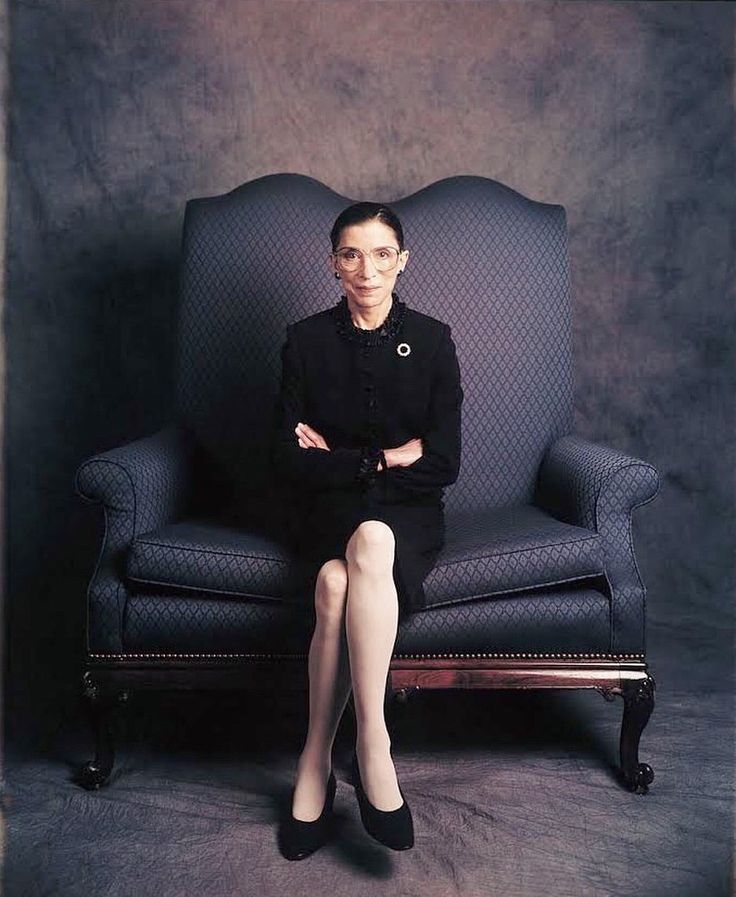 a woman sitting in a chair with her legs crossed