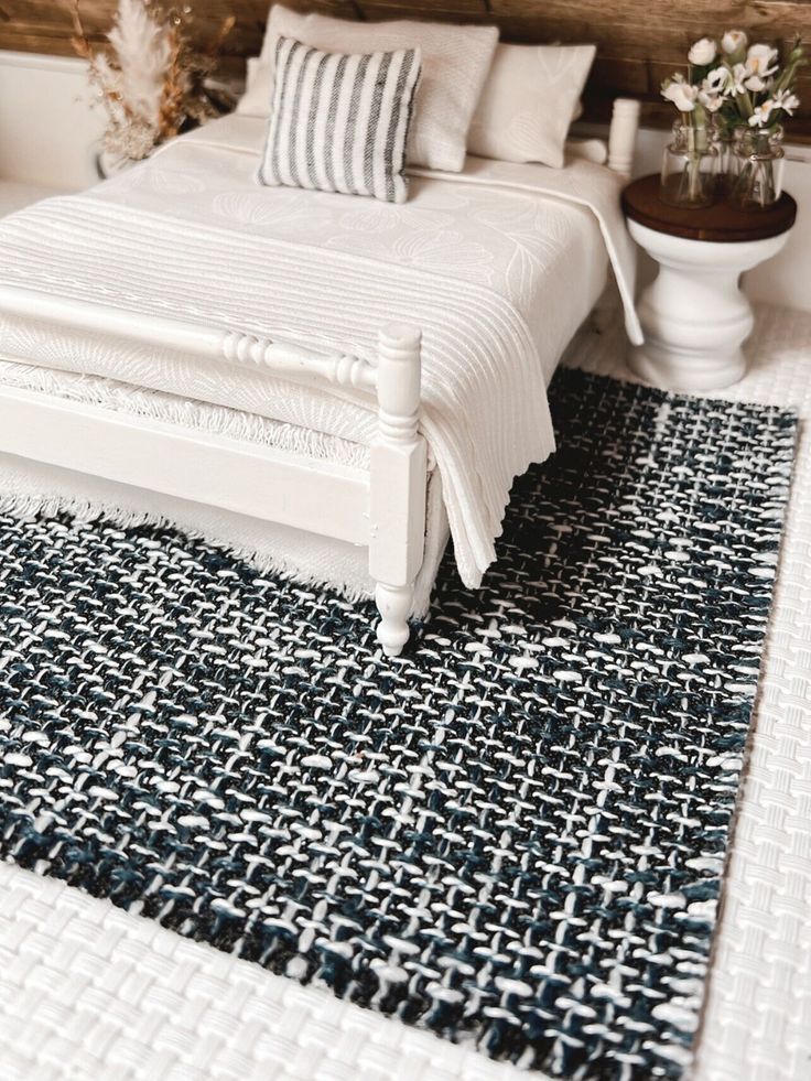 a white bed sitting next to a wooden headboard on top of a carpeted floor