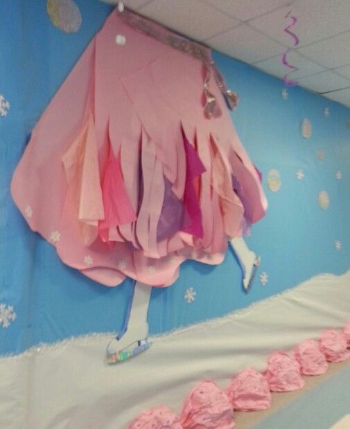 there is a pink umbrella hanging on the wall above cupcakes that are shaped like dresses