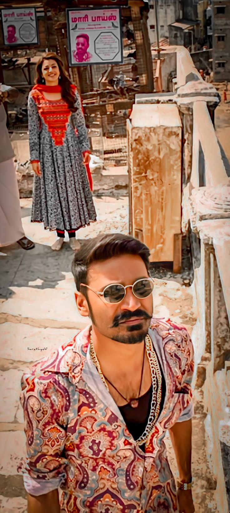 a man wearing sunglasses standing in front of an old building with other people behind him