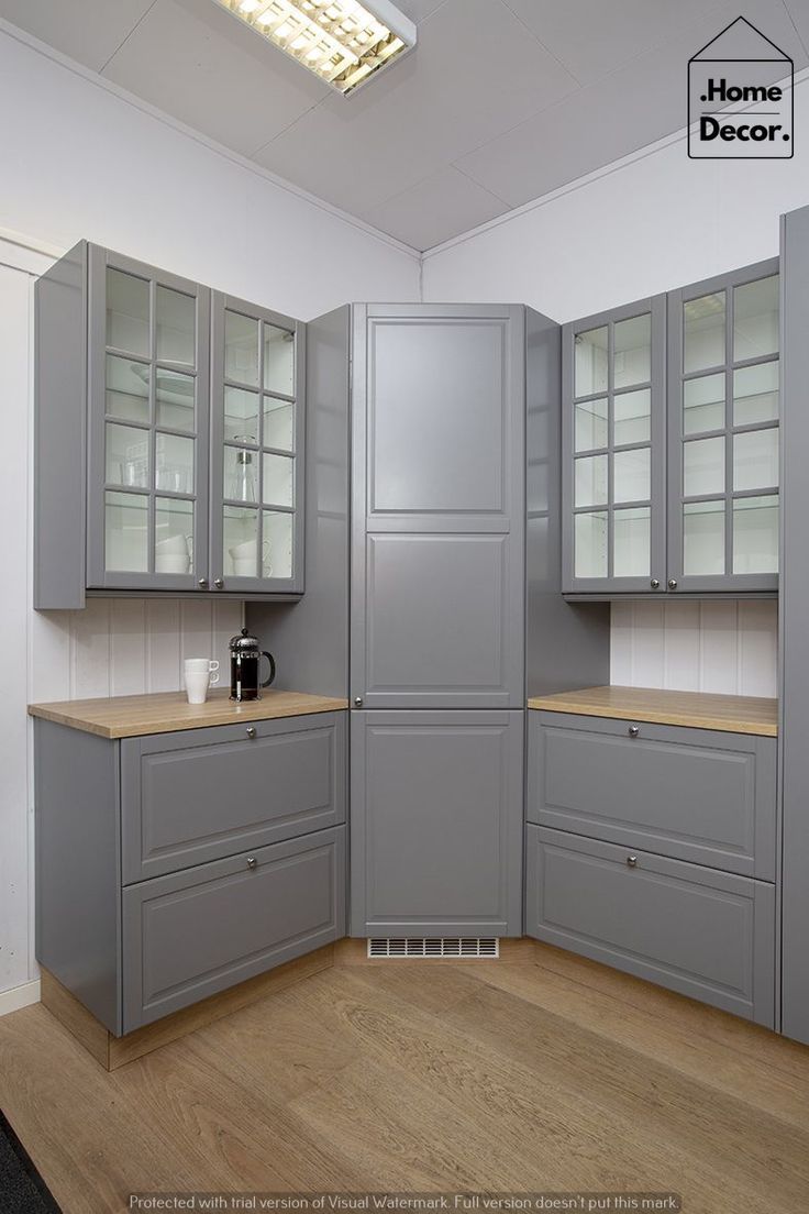 a kitchen with gray cabinets and wooden floors