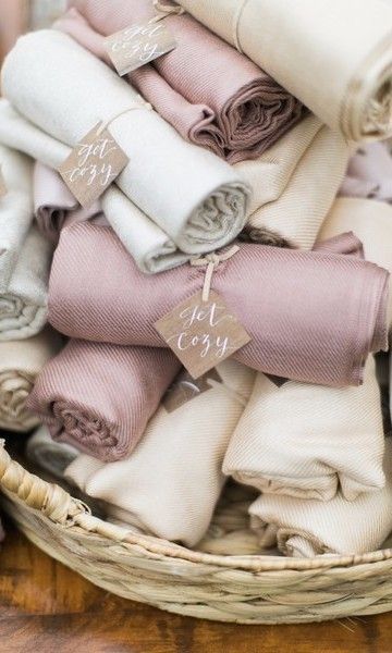 a basket filled with lots of folded blankets