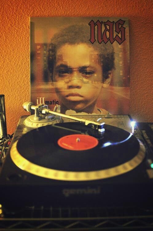 a record player sitting on top of a table next to a poster with an image of a young man