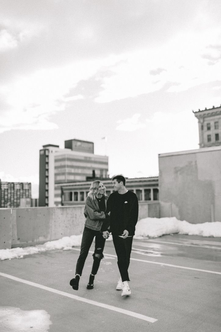 black and white photograph of two people standing in the middle of an empty parking lot