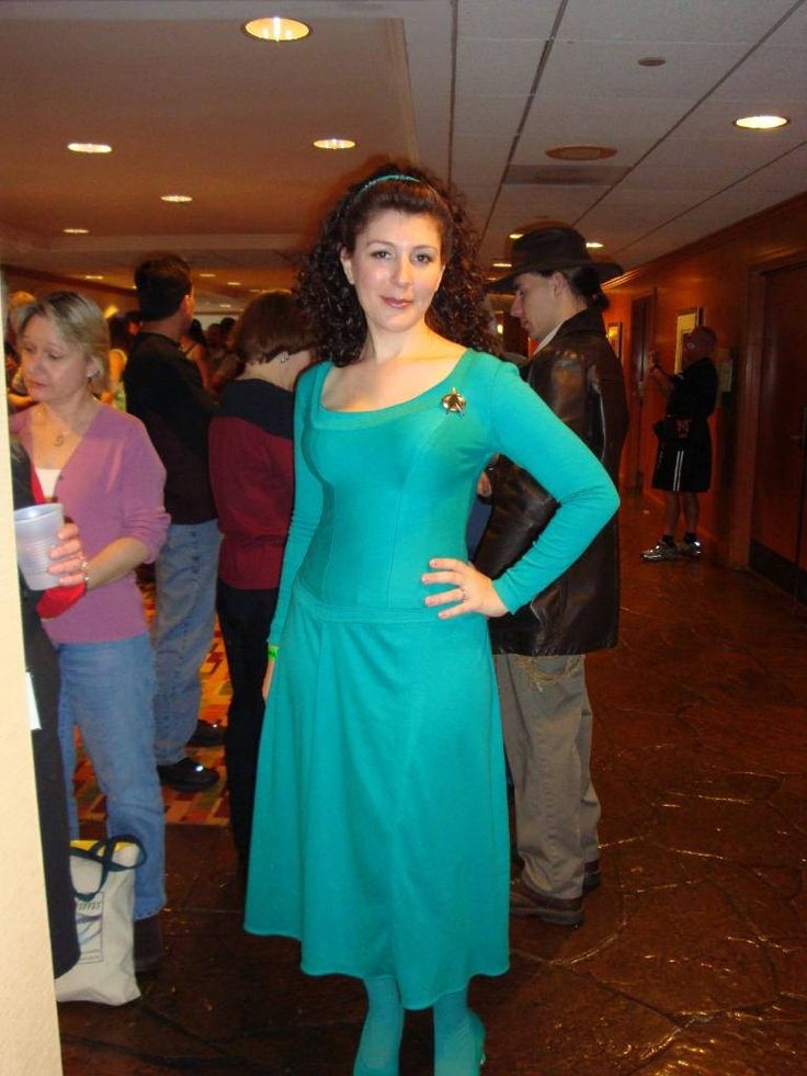 a woman in a blue dress is standing with her hands on her hips