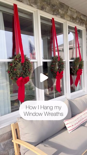 the front porch is decorated for christmas with wreaths and ribbons hanging from the windows