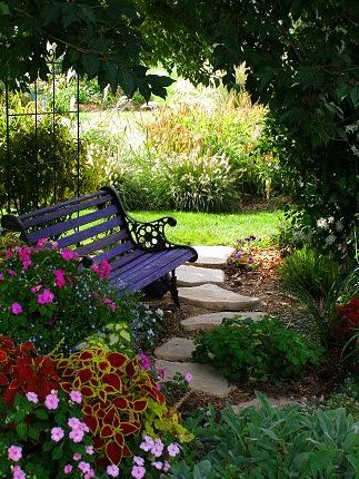 a wooden bench sitting in the middle of a garden