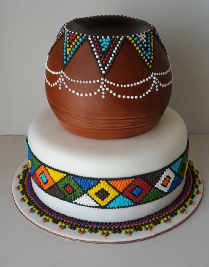 a three tiered cake with beaded designs on it's sides and a pot on top