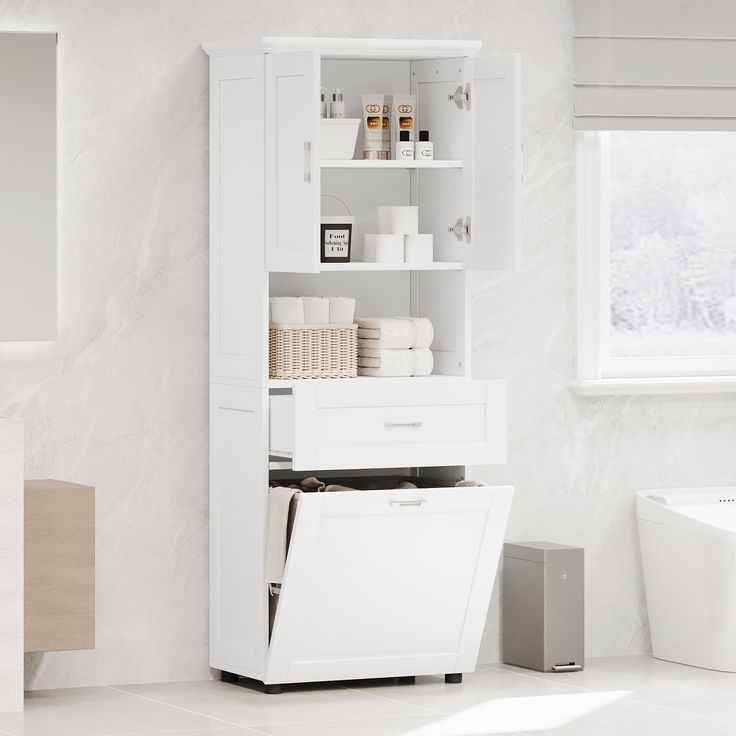 a white cabinet with drawers and towels on it in a bathroom next to a bathtub