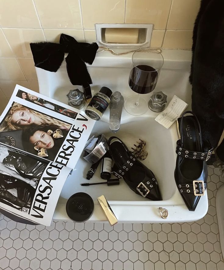 a sink filled with assorted shoes and other items next to a magazine on the floor