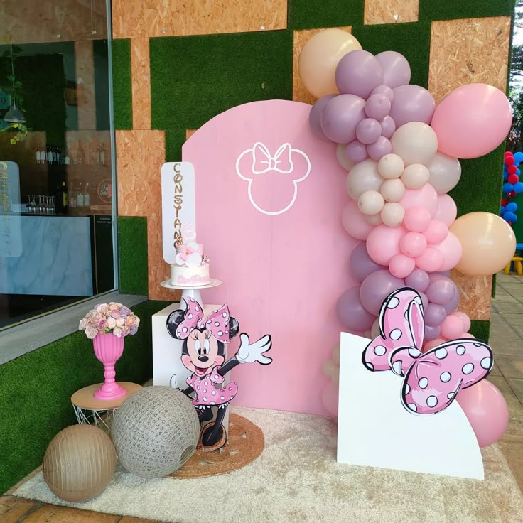 a minnie mouse themed birthday party with balloons and decorations