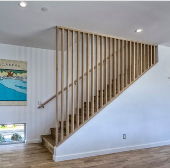 an empty living room with stairs leading up to the second floor and a painting on the wall