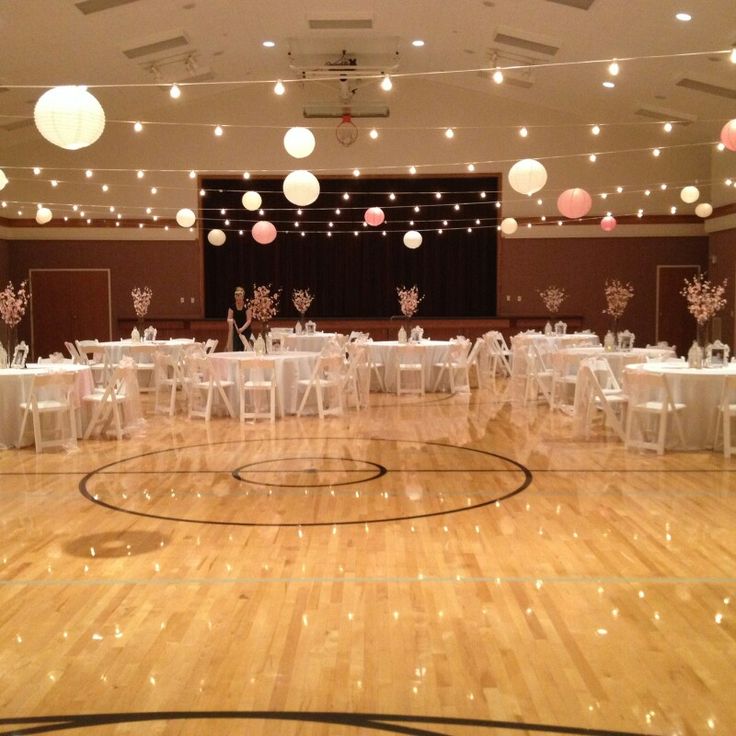 an indoor basketball court with tables and chairs set up for a banquet or wedding reception