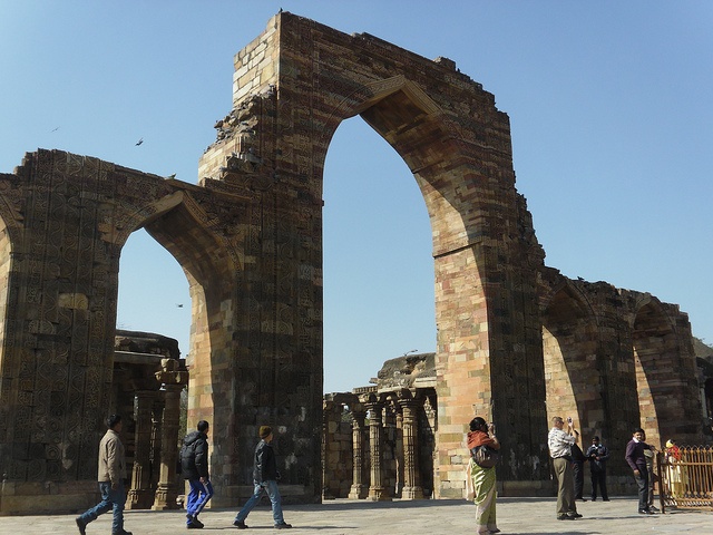 people are walking around in front of an old building that has been built into the ground