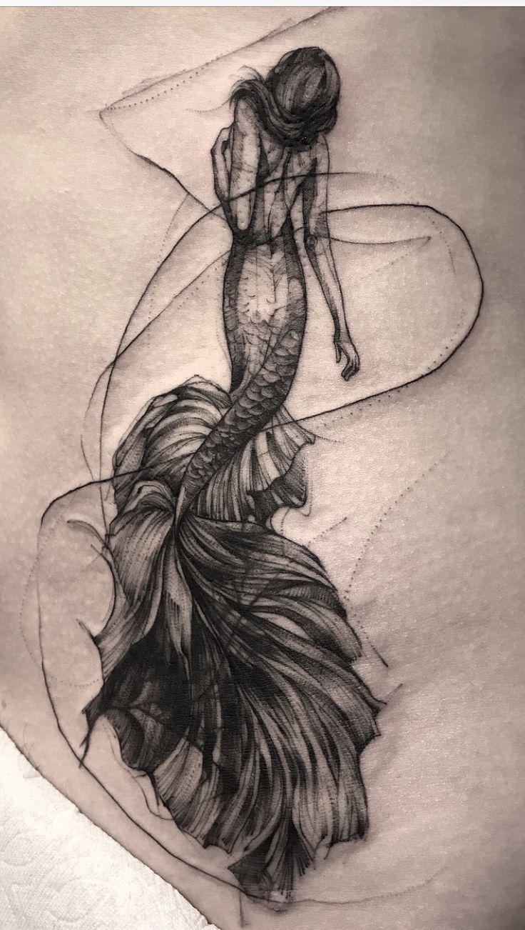 a woman's stomach with a black and white drawing of a mermaid on it