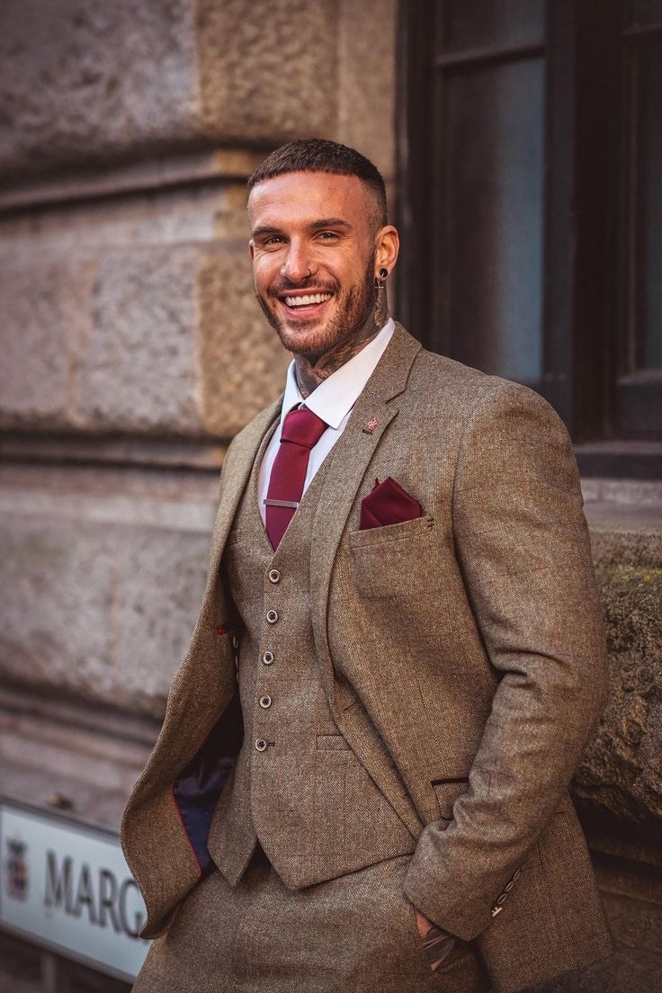 a man wearing a suit and tie standing in front of a building