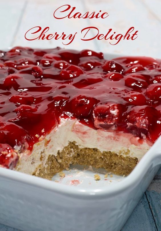 a close up of a cake in a pan with cherries on top and the words classic cherry delight