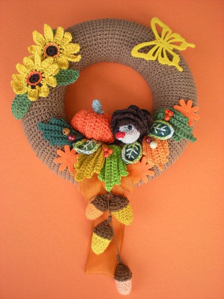 a crocheted wreath with sunflowers and birds hanging on the front door