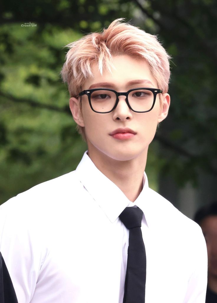 a young man wearing glasses and a tie