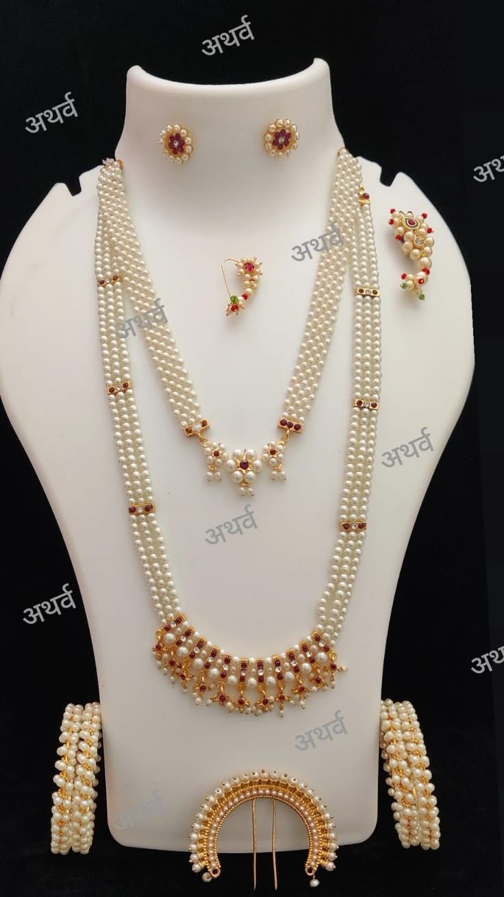 a necklace and earring set with pearls on display in a white mannequin