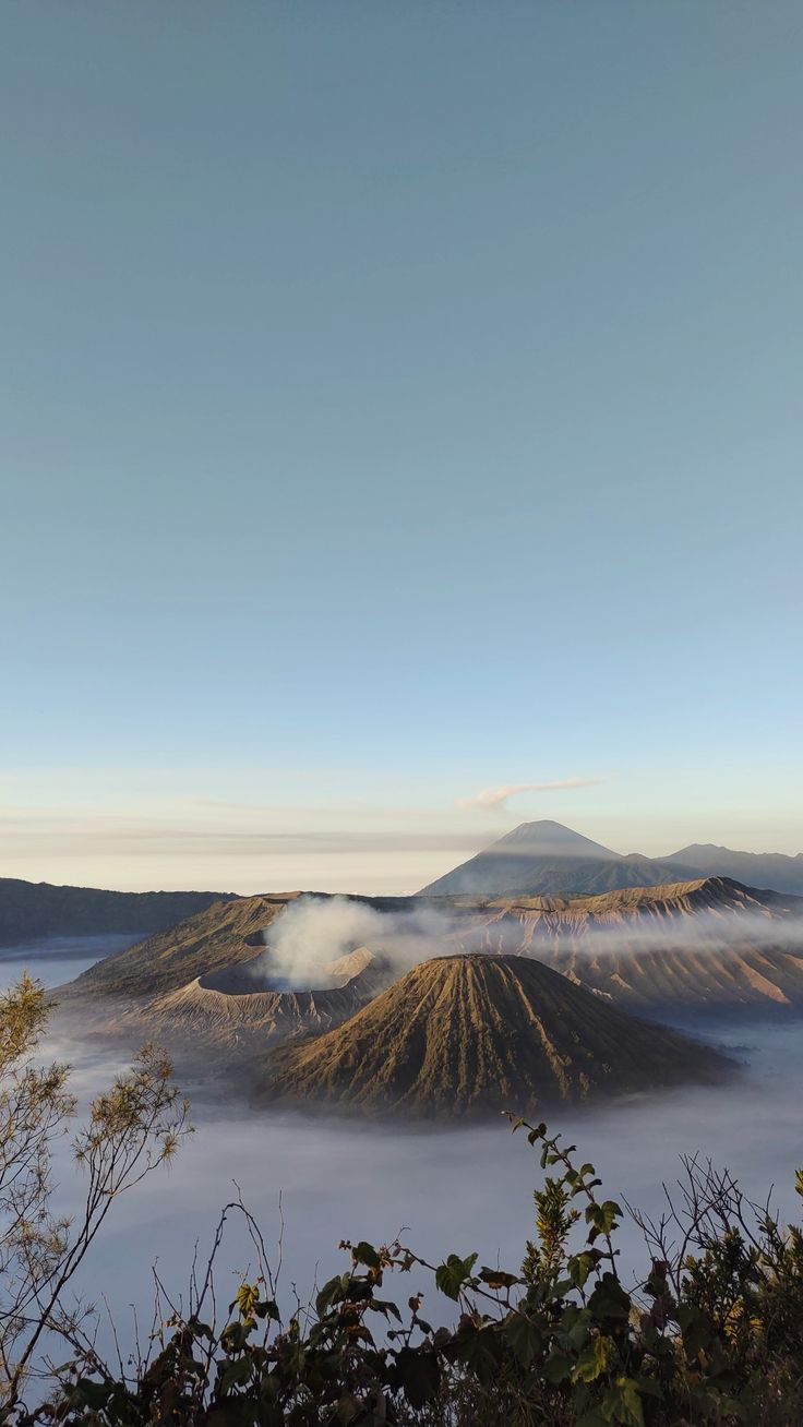 the clouds are low in the sky above the mountains