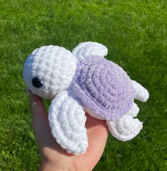 a small crocheted turtle is held in someone's hand