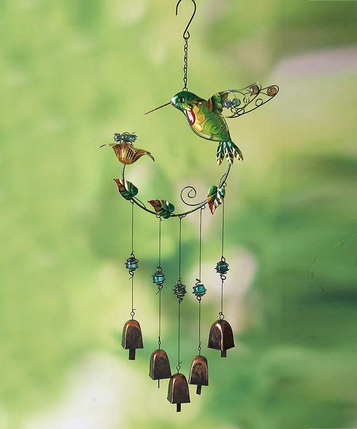 a hummingbird hanging from a wind chime with bells