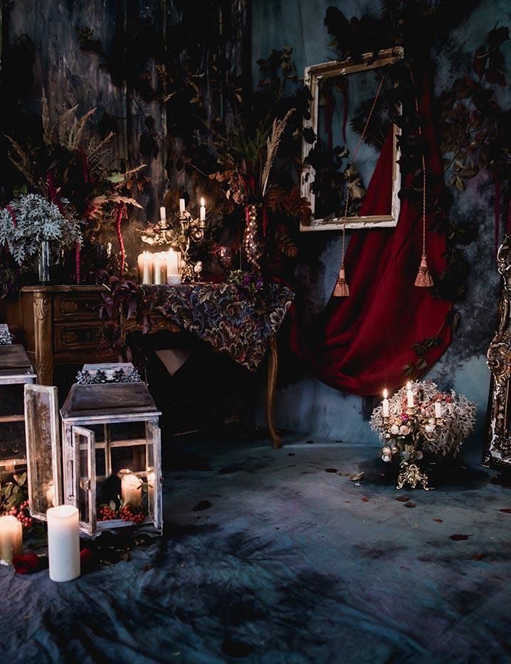 candles are lit on the floor in front of an ornate display with flowers and other decorations