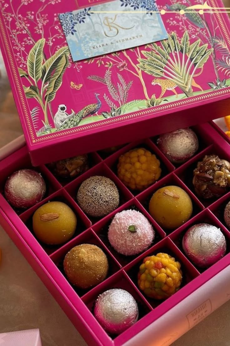 a pink box filled with lots of different types of candies