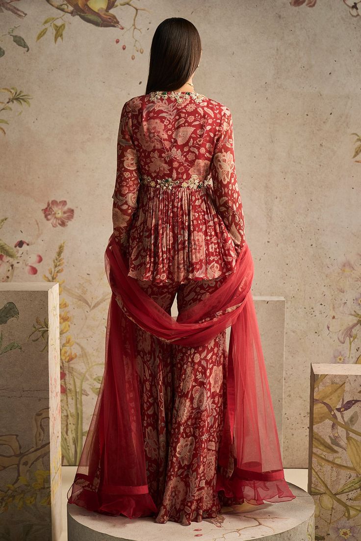 Elevate your style with this exquisite red ochre printed chiffon peplum set. The intricate prints and the flattering peplum design make it a perfect choice for festive occasions and celebrations. Paired with the printed chiffon gharara and a net dupatta, this ensemble radiates elegance and grace. Make a statement and leave a lasting impression with this stunning outfit. Printed Gharara Designs, Kurtis Patterns, Chiffon Gharara, Peplum Design, Ridhi Mehra, Haldi Outfits, Peplum Designs, Kurti Dress, Indian Kurti