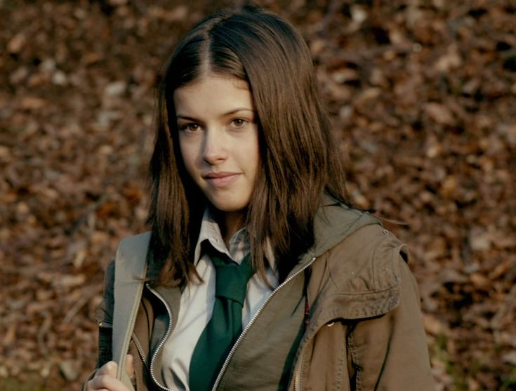 a young woman wearing a green tie and jacket