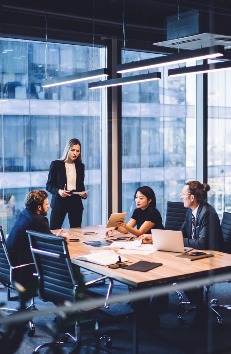 four people sitting around a conference table in an office